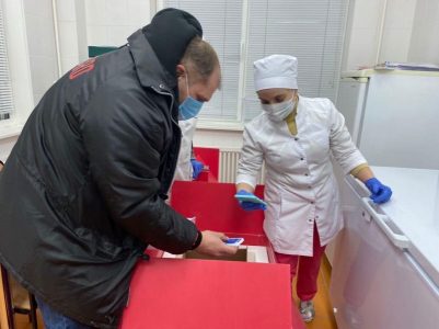 Врач принимает термоконтейнеры от грузчика. Biocard - перевозки термозависимых грузов с температурным режимом по РФ
